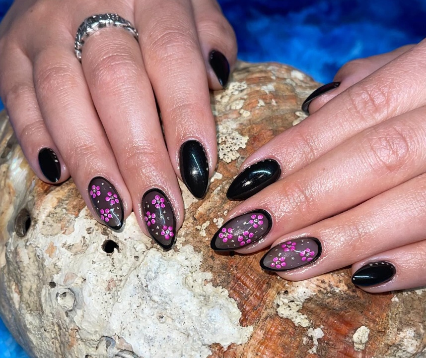 Hand-painted floral nail art by Sierra Earl — black gel with pink cherry blossom detail